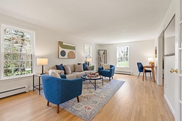 living area featuring baseboards, a baseboard heating unit, light wood-style flooring, and a baseboard radiator