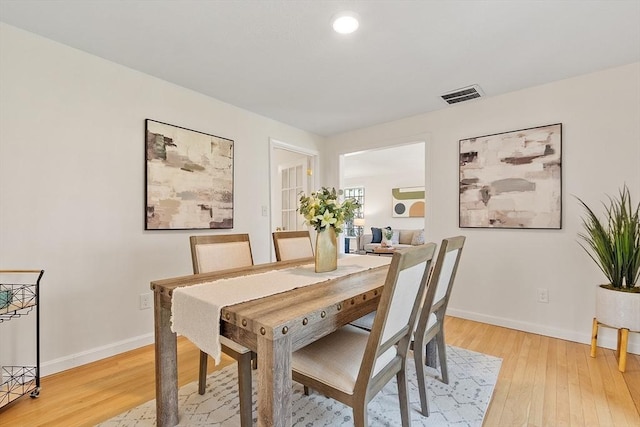 dining area with visible vents, baseboards, and light wood-style floors