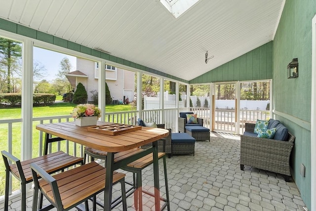 sunroom / solarium with a skylight and outdoor dining area