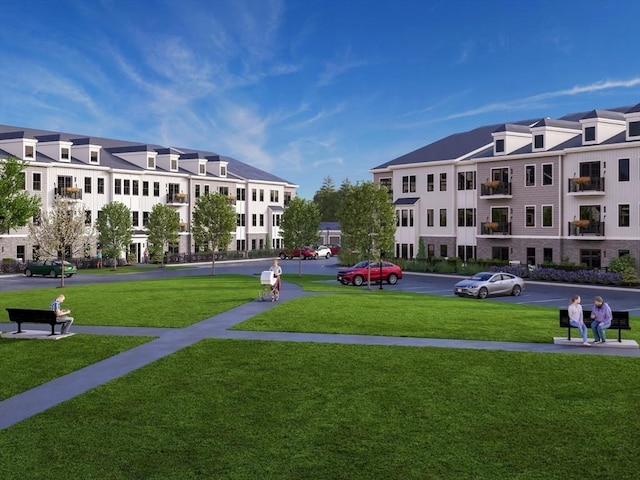 view of community with a lawn and uncovered parking