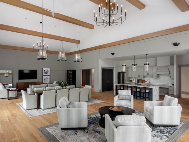 living room featuring high vaulted ceiling, beam ceiling, light wood-type flooring, and a chandelier
