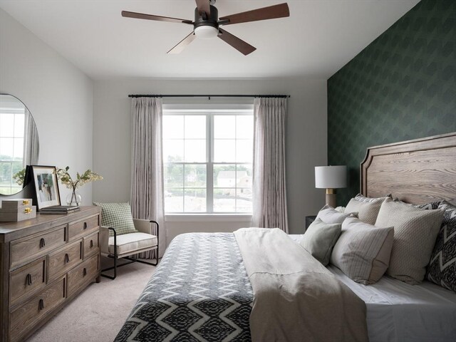 bedroom with light carpet and a ceiling fan