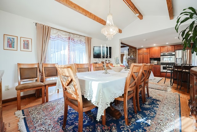 dining room featuring a chandelier, lofted ceiling with beams, and light wood-type flooring