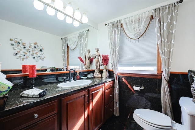 bathroom featuring tile walls, vanity, toilet, and tile patterned floors