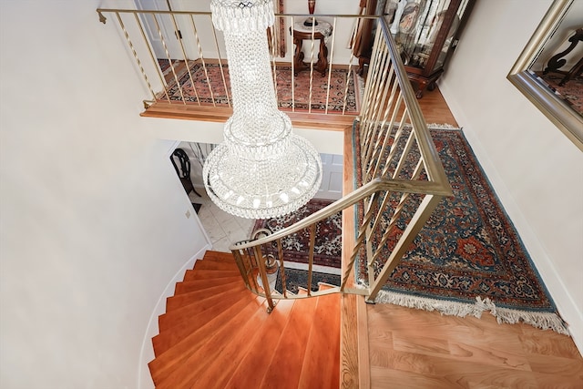 staircase featuring a notable chandelier and hardwood / wood-style flooring