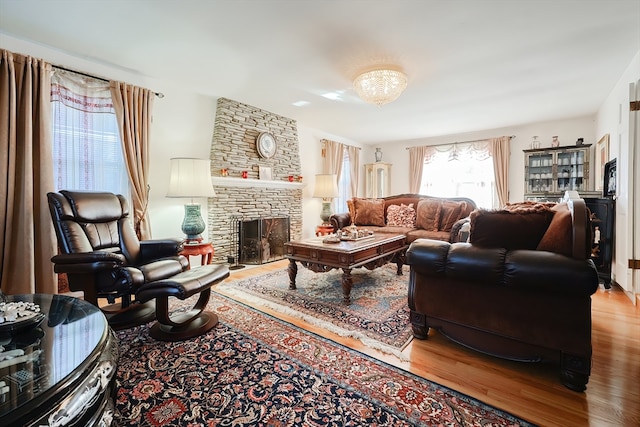 living room with a stone fireplace and hardwood / wood-style floors