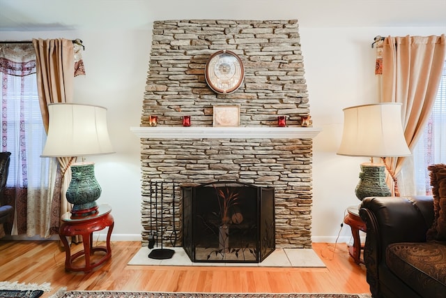 interior space with a stone fireplace and hardwood / wood-style floors