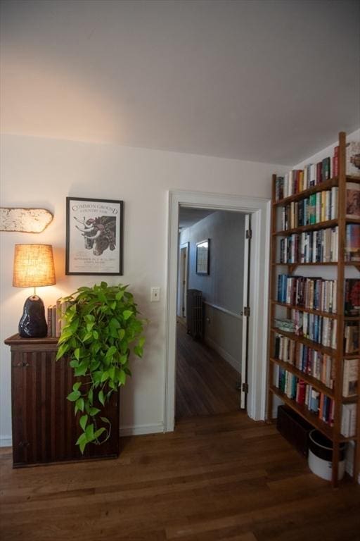 corridor with wood finished floors and baseboards