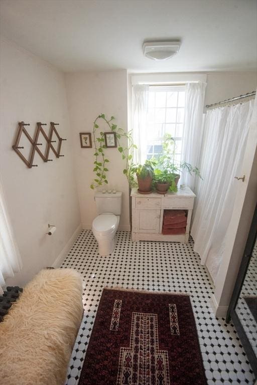 full bathroom featuring a shower stall, toilet, tile patterned floors, and baseboards