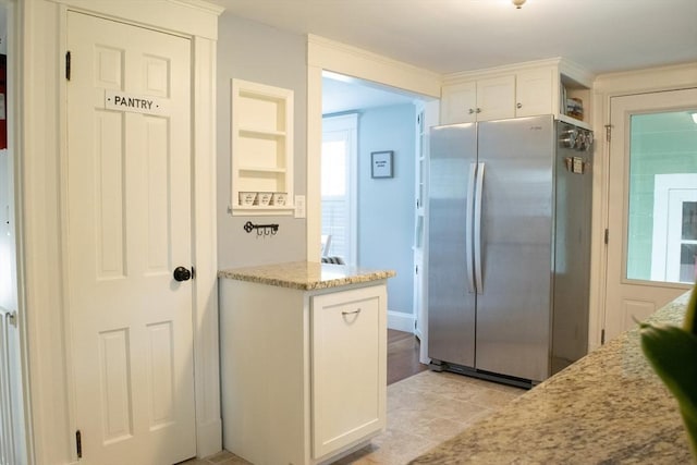 24 Garey St, Weymouth, MA 02189 - kitchen featuring freestanding refrigerator, white cabinetry, and light stone counters