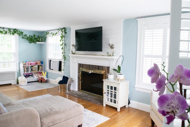 24 Garey St, Weymouth, MA 02189 - living area with radiator heating unit, cooling unit, a fireplace, and wood finished floors