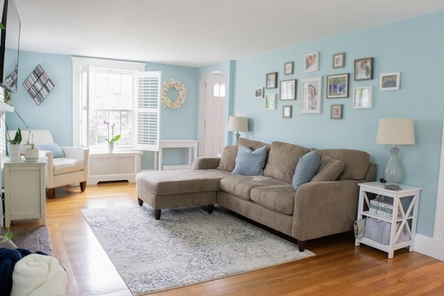 24 Garey St, Weymouth, MA 02189 - living area with radiator heating unit, arched walkways, healthy amount of natural light, and wood finished floors