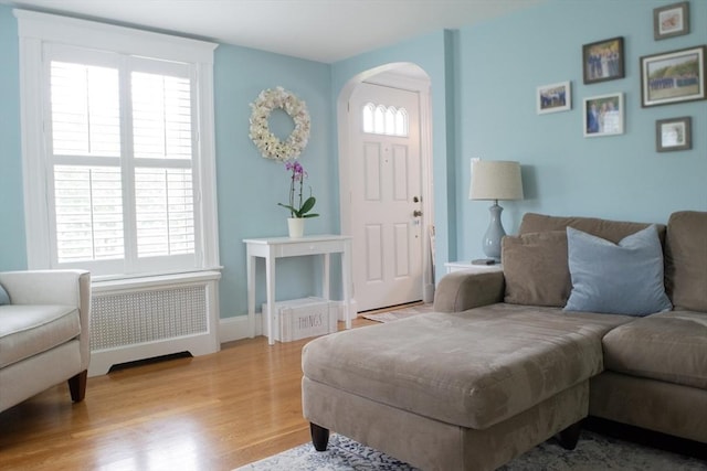24 Garey St, Weymouth, MA 02189 - living room with radiator, arched walkways, and wood finished floors