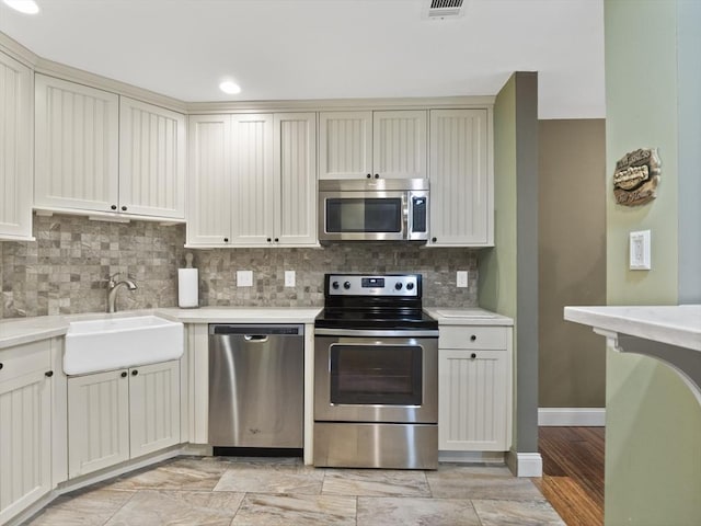 770 Salisbury Unit 302, Worcester, MA 01609 - kitchen featuring appliances with stainless steel finishes, light countertops, decorative backsplash, cream cabinetry, and recessed lighting