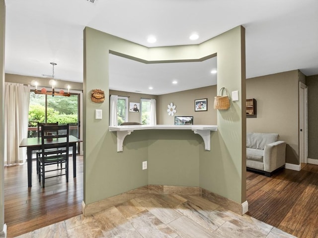 770 Salisbury Unit 302, Worcester, MA 01609 - kitchen featuring a breakfast bar area, a chandelier, a peninsula, wood finished floors, and recessed lighting