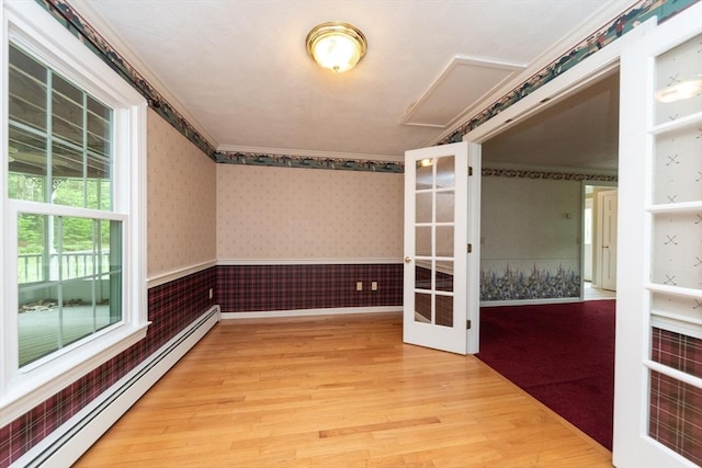 10 Eagle Rd, Winchendon, MA 01475 - spare room featuring a baseboard heating unit, wood finished floors, wainscoting, wallpapered walls, and french doors