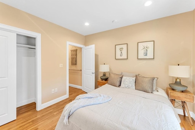 bedroom featuring recessed lighting, baseboards, a closet, and light wood-type flooring