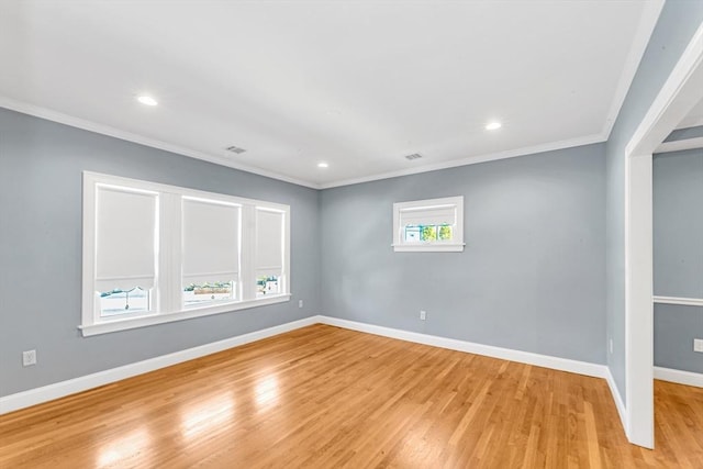 empty room featuring baseboards, light wood-style flooring, and crown molding