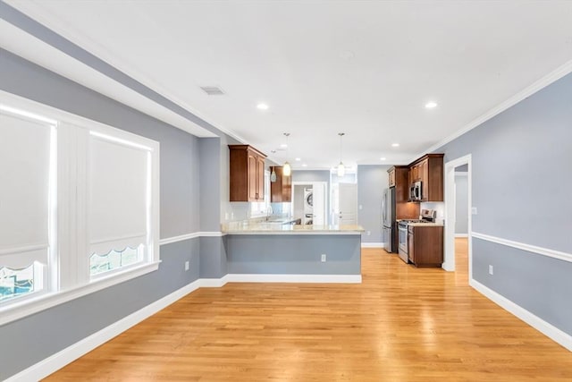 kitchen with a peninsula, light countertops, light wood finished floors, hanging light fixtures, and stainless steel appliances