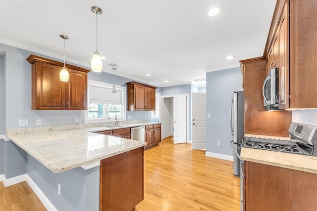 kitchen with a peninsula, a kitchen breakfast bar, a sink, light wood-style flooring, and stainless steel appliances
