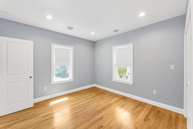 unfurnished room featuring recessed lighting, baseboards, light wood-type flooring, and visible vents