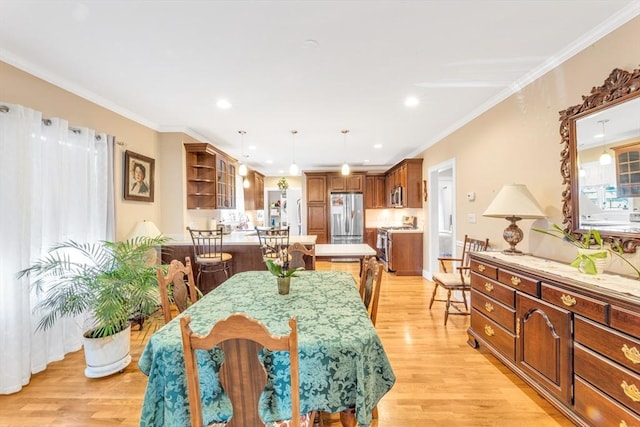 dining room featuring recessed lighting, ornamental molding, and light wood finished floors