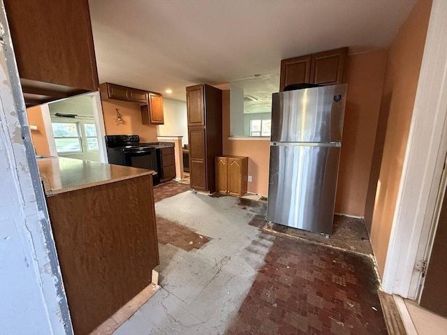 208 Rhode Island Rd, Lakeville, MA 02347 - kitchen featuring brown cabinetry, freestanding refrigerator, and black range with electric cooktop