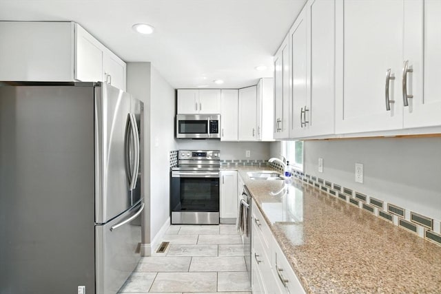 606 Granby Rd, South Hadley, MA 01075 - kitchen featuring appliances with stainless steel finishes, recessed lighting, white cabinetry, and light stone countertops