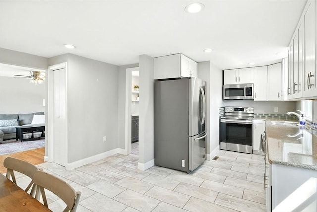 606 Granby Rd, South Hadley, MA 01075 - kitchen featuring appliances with stainless steel finishes, white cabinetry, recessed lighting, light stone countertops, and ceiling fan