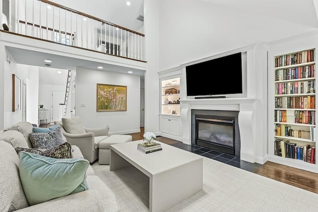 1003 Wisteria Way Unit 1003, Wayland, MA 01778 - living area featuring a fireplace with flush hearth, built in shelves, baseboards, recessed lighting, and a high ceiling