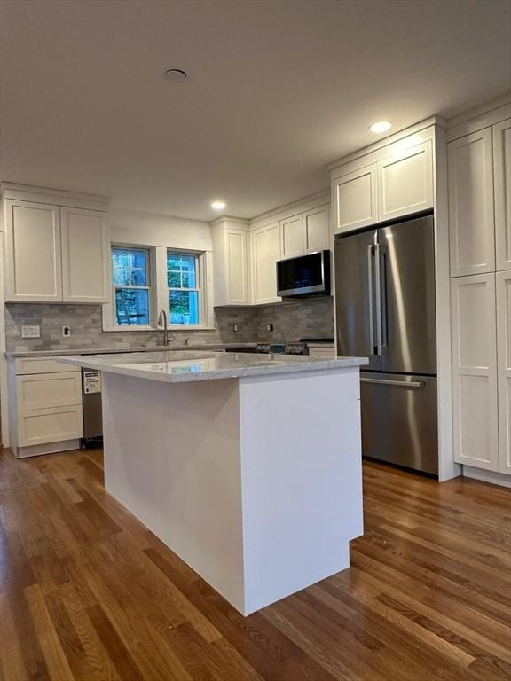 2 Wilkins Pl, Boston, MA 02131 - kitchen featuring stainless steel appliances, white cabinetry, a center island, decorative backsplash, and dark wood finished floors