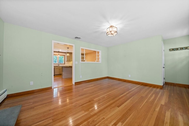 73 Fremont St, Taunton, MA 02780 - unfurnished living room with light wood-style flooring, baseboards, a sink, and a chandelier