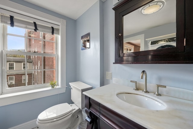 bathroom featuring vanity, toilet, and a healthy amount of sunlight