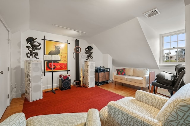 living room featuring lofted ceiling and hardwood / wood-style flooring