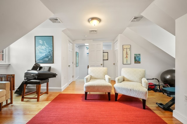 sitting room with vaulted ceiling and light wood-type flooring