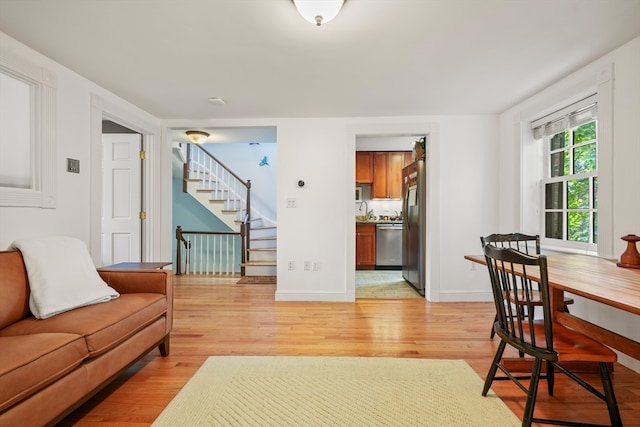 living room featuring light wood-type flooring and sink