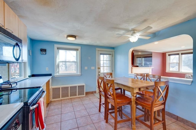 dining space featuring plenty of natural light, light tile patterned floors, a textured ceiling, and ceiling fan