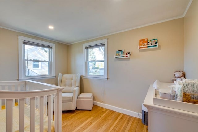 bedroom with multiple windows, crown molding, and light wood-type flooring