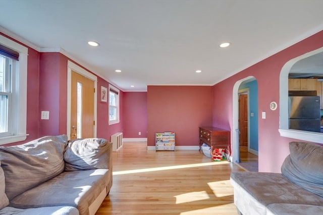 living room featuring hardwood / wood-style flooring and crown molding