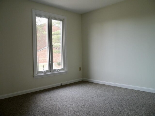 empty room featuring carpet flooring and baseboards