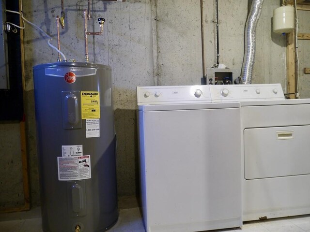 clothes washing area featuring laundry area, water heater, and washer and clothes dryer