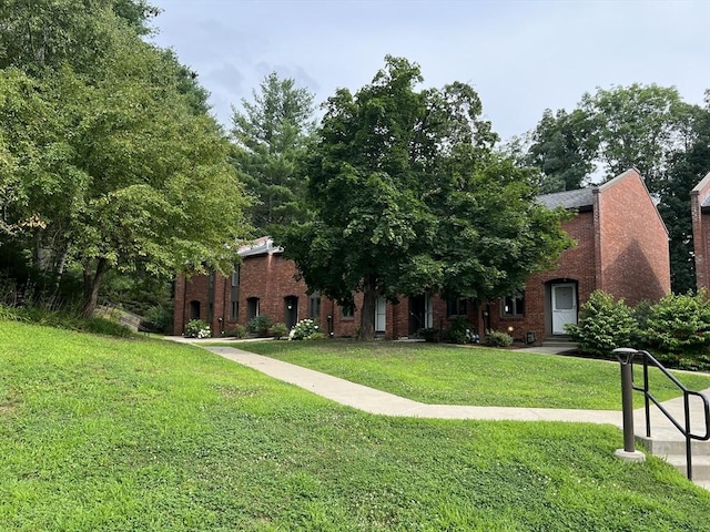 view of front of house with brick siding and a front yard