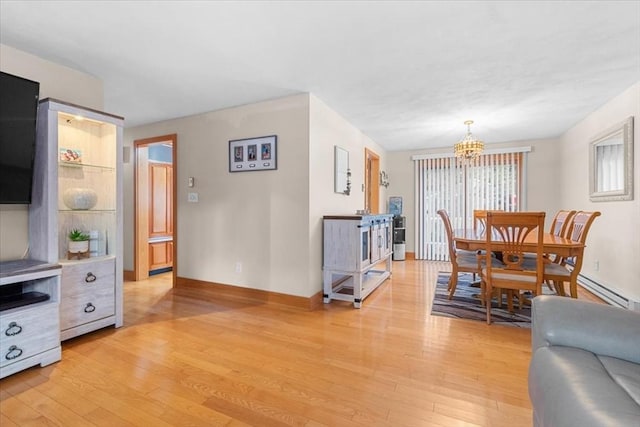 dining area featuring an inviting chandelier, light wood-style flooring, and baseboards