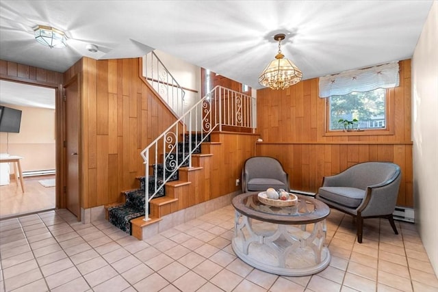 sitting room featuring stairway, a baseboard radiator, tile patterned floors, and wooden walls