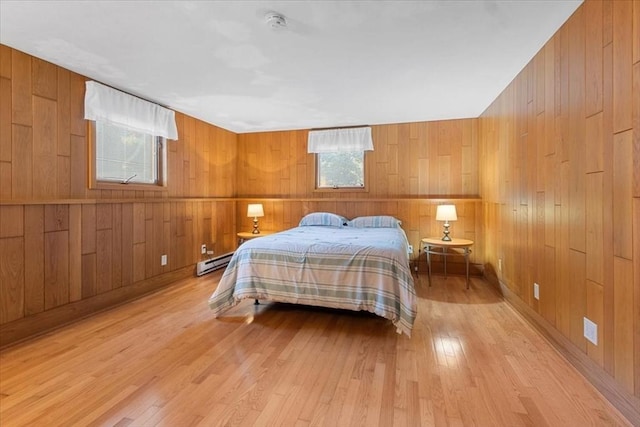 bedroom with light wood-style floors and baseboard heating