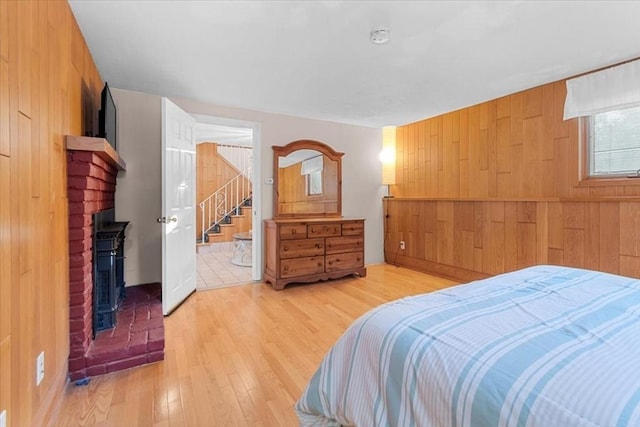 bedroom with wood walls and light wood-style floors