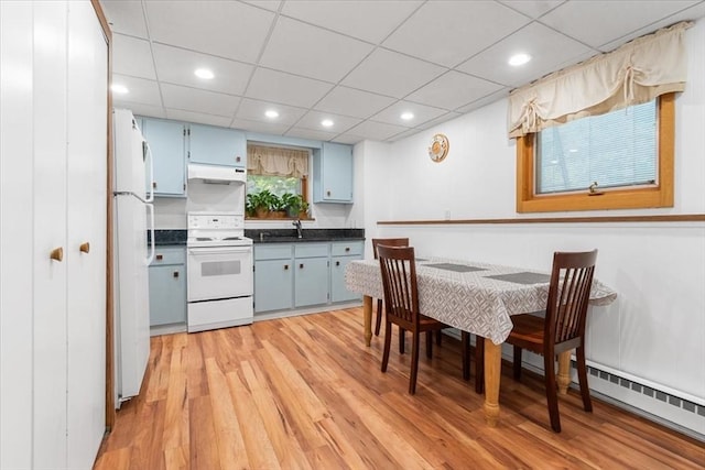 kitchen featuring a sink, white appliances, blue cabinetry, and under cabinet range hood