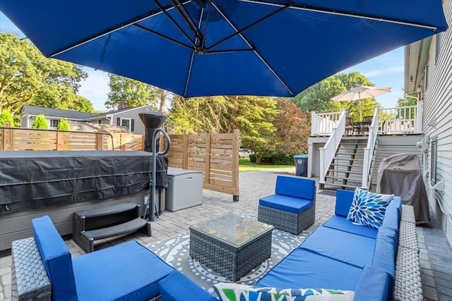 view of patio featuring an outdoor hangout area, fence, a hot tub, and stairs