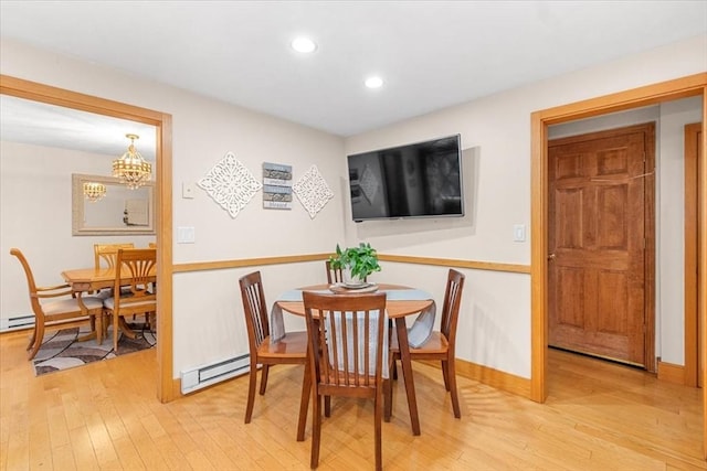 dining space with a baseboard heating unit, recessed lighting, light wood-style flooring, and baseboards