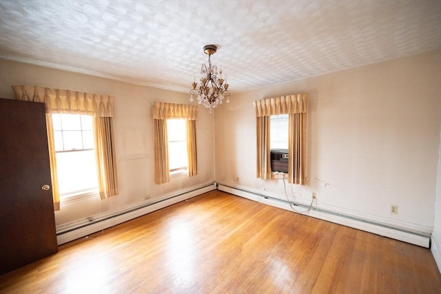 102 Margin St, Salem, MA 01970 - spare room featuring a chandelier, plenty of natural light, wood finished floors, and a baseboard radiator